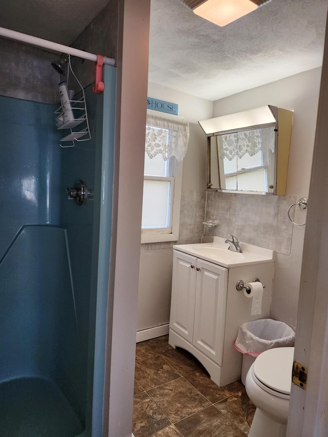 bathroom featuring vanity, toilet, walk in shower, and a textured ceiling