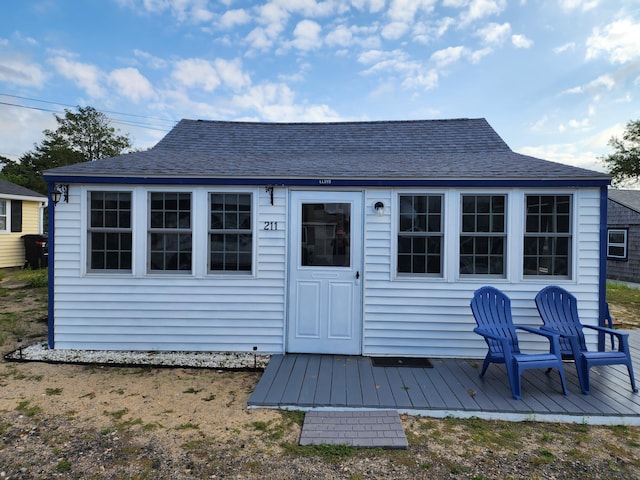 rear view of property featuring a wooden deck