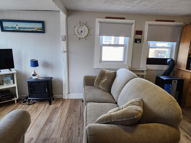 living room featuring hardwood / wood-style flooring, wooden walls, and a wood stove