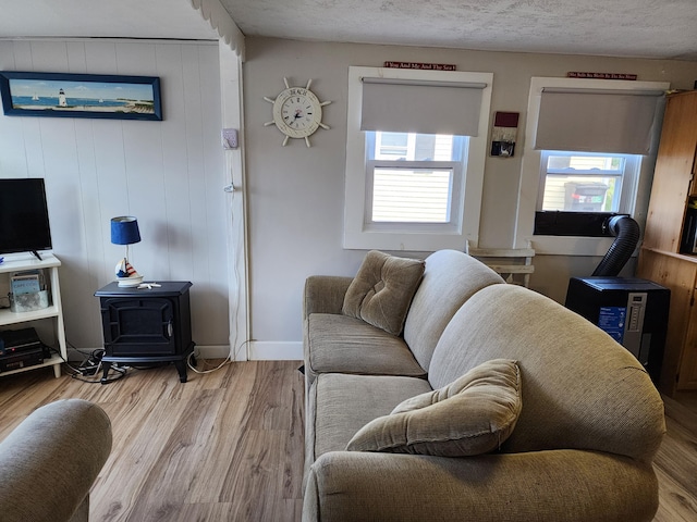 living room featuring wood walls, hardwood / wood-style floors, and a wood stove