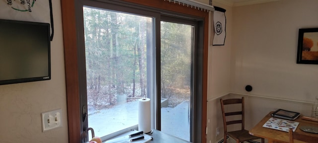 doorway to outside featuring ornamental molding and plenty of natural light