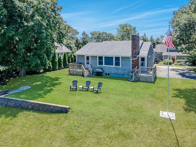 back of property with a deck and a yard