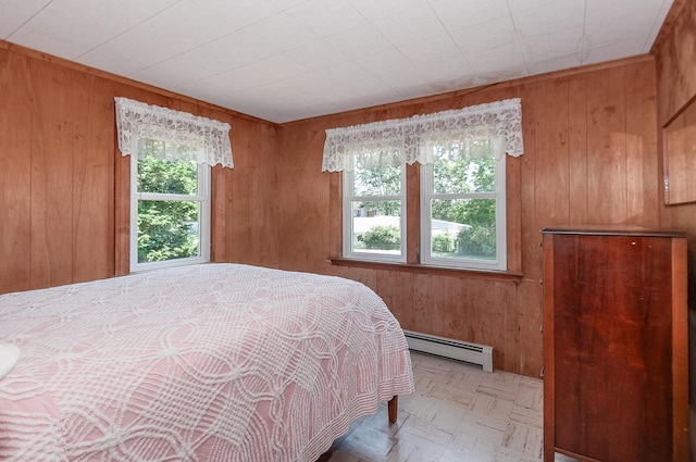 bedroom featuring wooden walls and baseboard heating