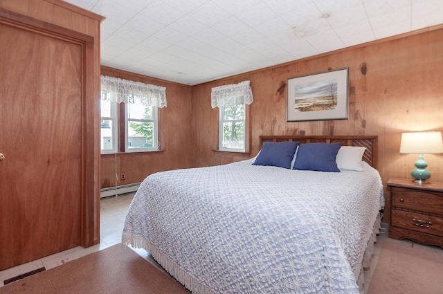 bedroom with baseboard heating, wooden walls, and light tile patterned flooring