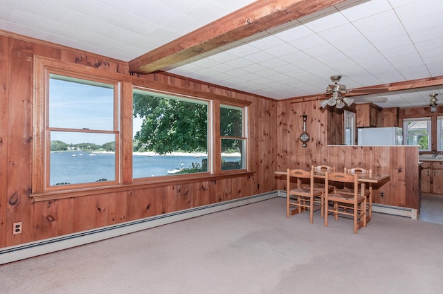 dining space with baseboard heating, a water view, beam ceiling, and carpet flooring