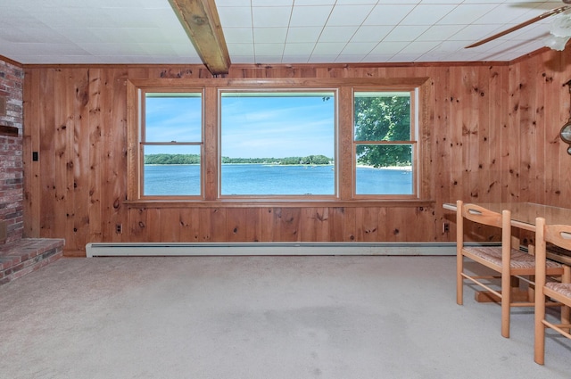 interior space featuring ceiling fan, a water view, carpet floors, wood walls, and beamed ceiling