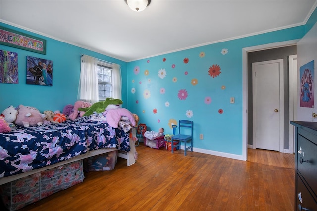 bedroom featuring crown molding, baseboards, and hardwood / wood-style floors