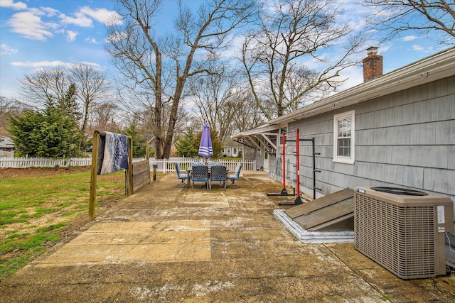 view of yard featuring central AC, outdoor dining space, and fence
