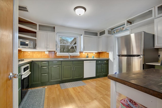 kitchen featuring green cabinets, white cabinetry, open shelves, a sink, and stainless steel appliances