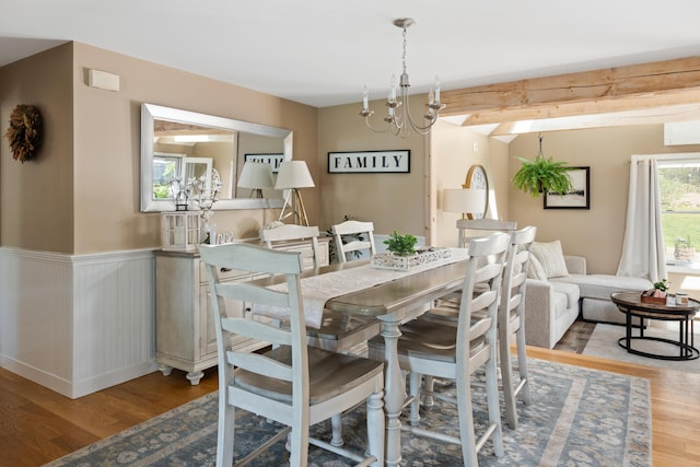 dining room with a chandelier, light hardwood / wood-style flooring, and a wall unit AC