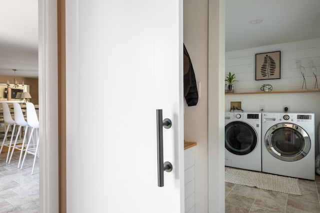 washroom with an inviting chandelier and washer and clothes dryer