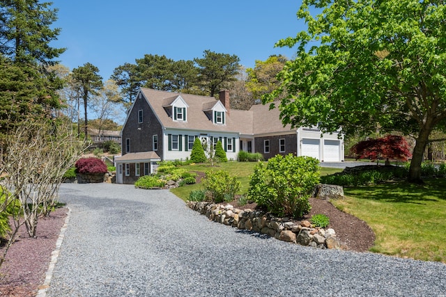 new england style home featuring a front yard and a garage