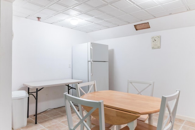 dining space featuring light tile patterned floors and baseboards