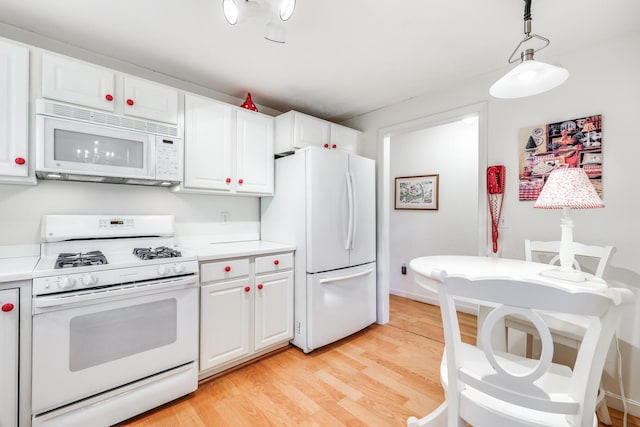 kitchen featuring pendant lighting, white appliances, light hardwood / wood-style flooring, and white cabinetry