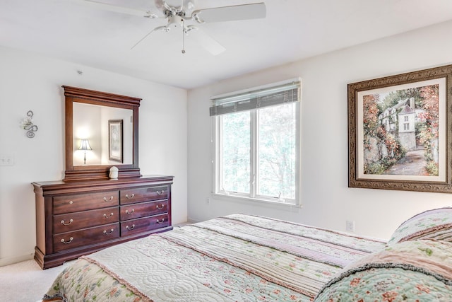 bedroom featuring light carpet, ceiling fan, and baseboards