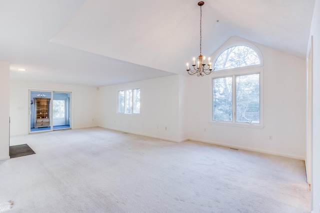 empty room featuring visible vents, baseboards, a chandelier, lofted ceiling, and light carpet