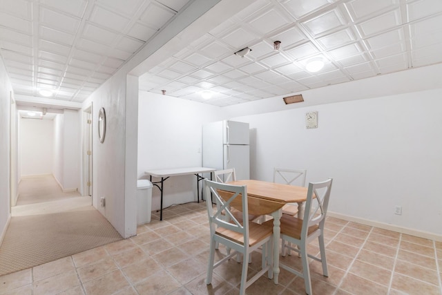 dining space featuring light tile patterned flooring, baseboards, and an ornate ceiling