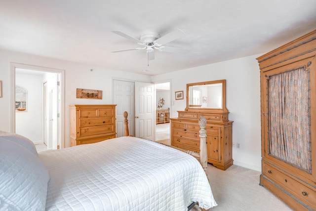 bedroom with a closet, ceiling fan, and light colored carpet