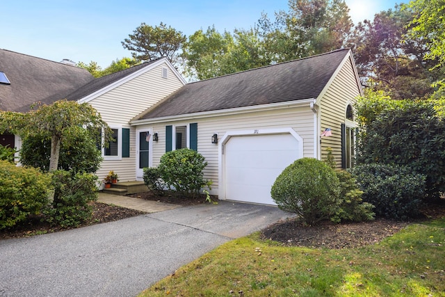 view of front of house featuring a garage, roof with shingles, and aphalt driveway