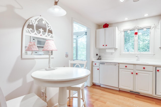 kitchen with dishwasher, white cabinetry, light hardwood / wood-style floors, sink, and hanging light fixtures