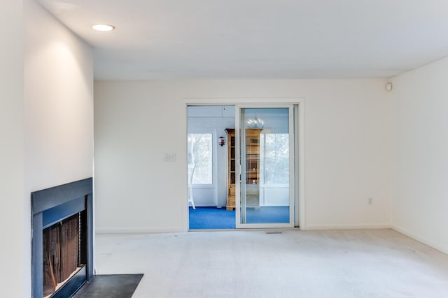 unfurnished living room featuring baseboards, a multi sided fireplace, and carpet floors