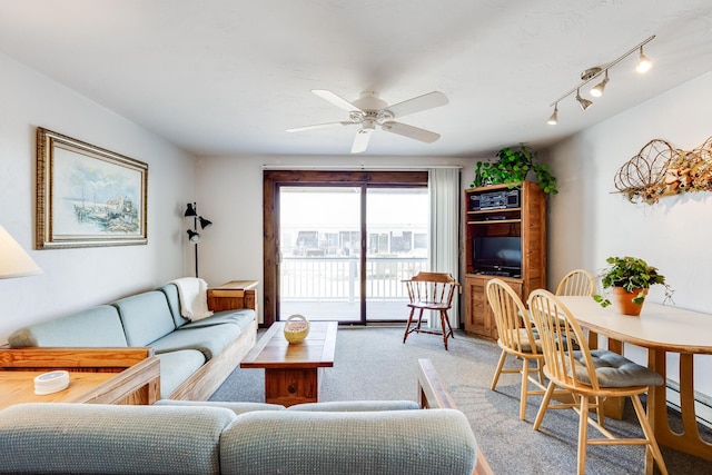 living room featuring rail lighting, carpet floors, and ceiling fan