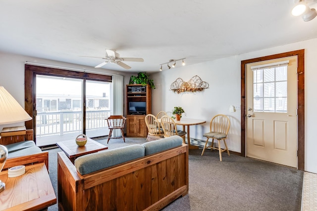 carpeted living room featuring ceiling fan and a baseboard heating unit