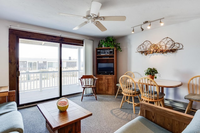 living room with rail lighting, carpet, a baseboard heating unit, and ceiling fan