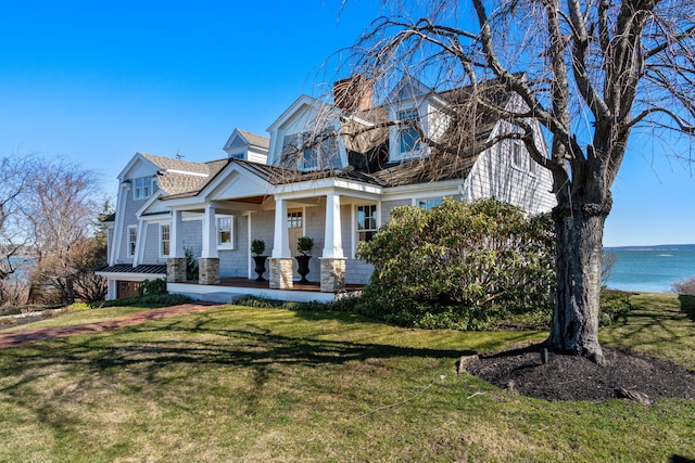 cape cod-style house featuring a water view, a front yard, and covered porch