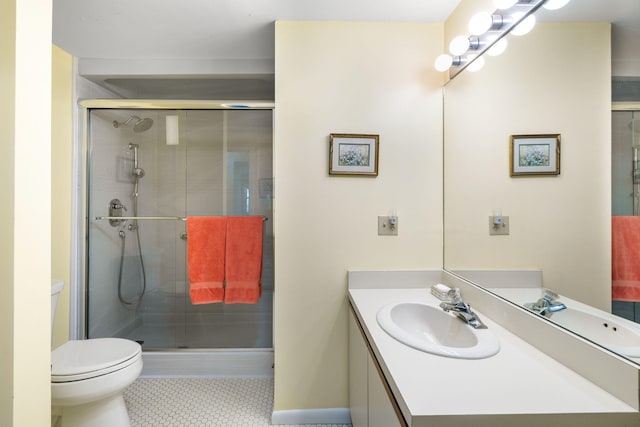 full bathroom featuring vanity, toilet, baseboards, tile patterned floors, and a shower stall