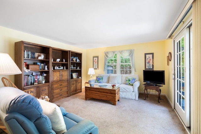 carpeted living area featuring baseboards
