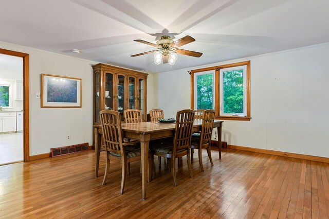 7 Bittersweet Ln, South Dennis, MA 02660 - kitchen featuring a sink, stainless steel microwave, freestanding refrigerator, white cabinetry, and light countertops