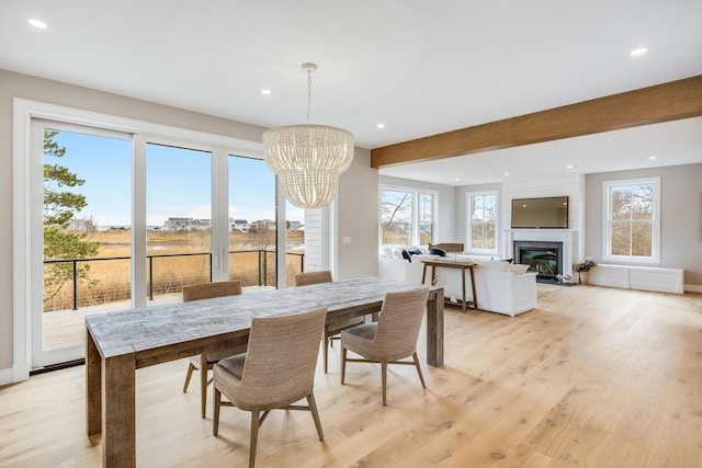 179 Beebe Acres Rd, Falmouth, MA 02540 - dining space with an inviting chandelier, a glass covered fireplace, light wood finished floors, and recessed lighting
