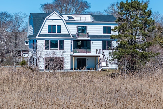 179 Beebe Acres Rd, Falmouth, MA 02540 - rear view of property with stairway, a gambrel roof, a balcony, and roof with shingles