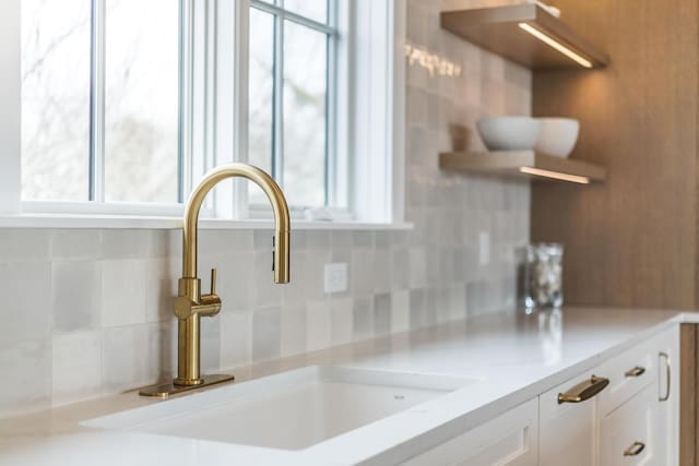 179 Beebe Acres Rd, Falmouth, MA 02540 - details with white cabinets, open shelves, light countertops, a sink, and tasteful backsplash
