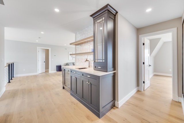179 Beebe Acres Rd, Falmouth, MA 02540 - kitchen featuring open shelves, a sink, beverage cooler, light wood-style floors, and baseboards