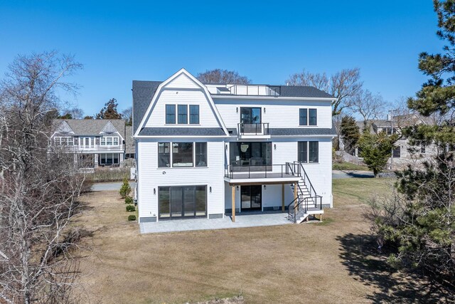 179 Beebe Acres Rd, Falmouth, MA 02540 - back of property with a gambrel roof, a shingled roof, a balcony, a yard, and a patio