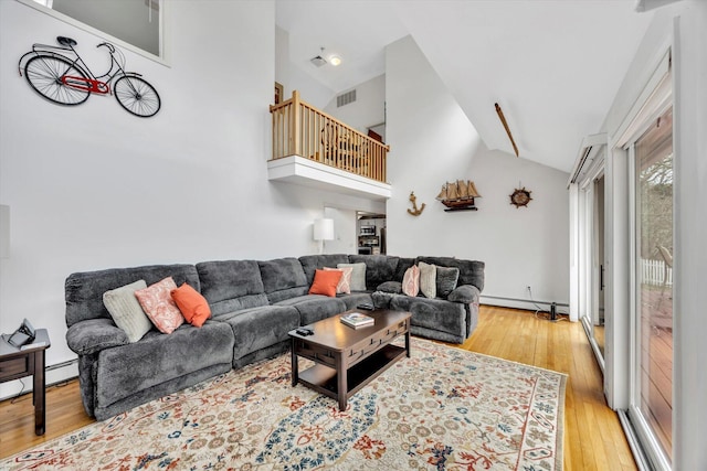 11 Elizabeth Ln, West Yarmouth, MA 02673 - living room with high vaulted ceiling, light wood-style flooring, visible vents, stairs, and a baseboard radiator