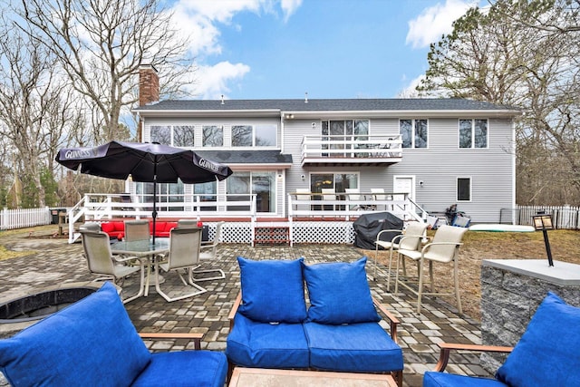 11 Elizabeth Ln, West Yarmouth, MA 02673 - rear view of property with a chimney, outdoor dining space, fence, a patio, and a wooden deck