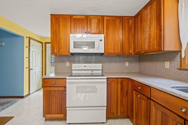 130 Surrey Ln, Brewster, MA 02631 - kitchen with light floors, brown cabinetry, and white appliances