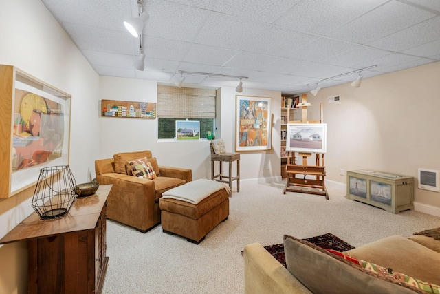 carpeted living area featuring track lighting, visible vents, and baseboards
