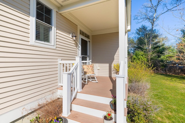 doorway to property with a porch and a yard