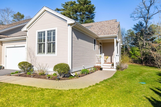 view of front of house featuring a front lawn, aphalt driveway, roof with shingles, and a garage