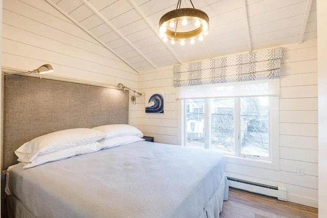 bedroom featuring wood walls, hardwood / wood-style floors, and a baseboard radiator