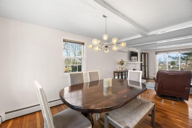 dining area featuring a baseboard heating unit, a chandelier, wood finished floors, and beamed ceiling