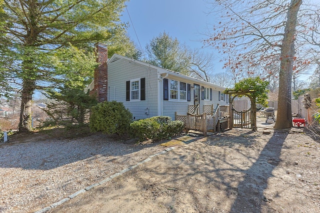 view of property exterior featuring a chimney, a gate, and fence