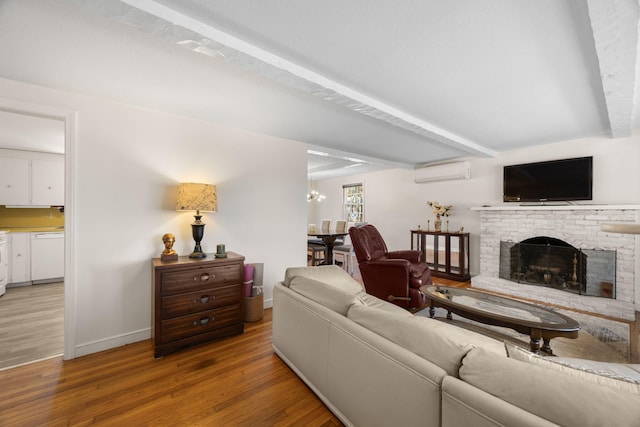 living area with light wood-style flooring, a fireplace, baseboards, beam ceiling, and a wall mounted air conditioner