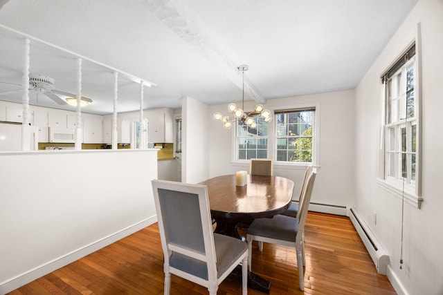 dining area featuring light wood-type flooring, baseboards, a baseboard heating unit, and ceiling fan with notable chandelier