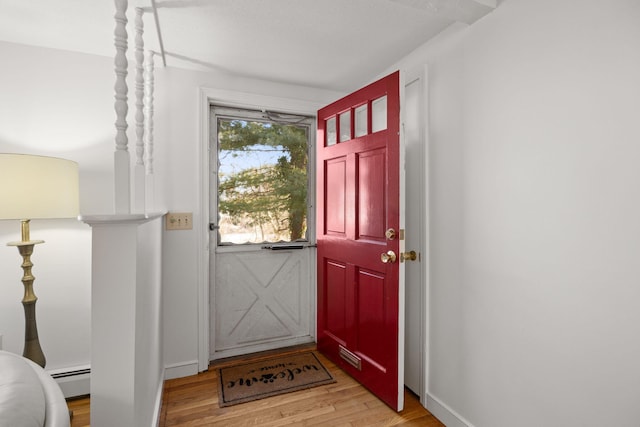 entrance foyer with light wood-type flooring, baseboards, and a baseboard heating unit