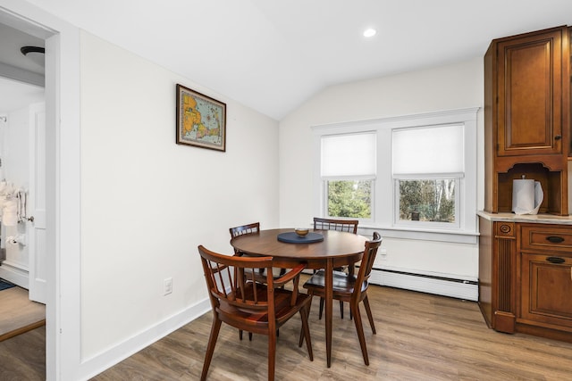 dining space featuring a baseboard radiator, recessed lighting, lofted ceiling, wood finished floors, and baseboards